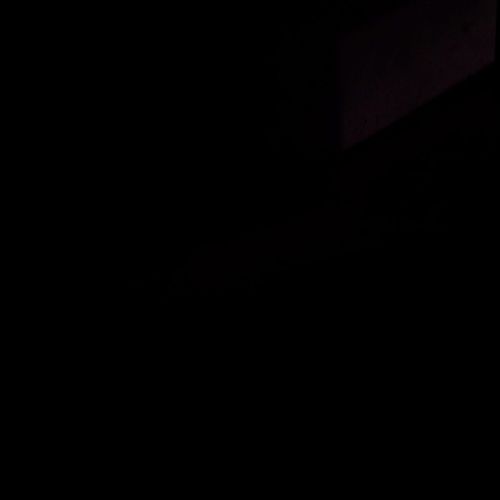 A softly lit open window with sheer curtains billowing inward, warm amber light spilling across a wooden sill, deep plum shadows in the corners.